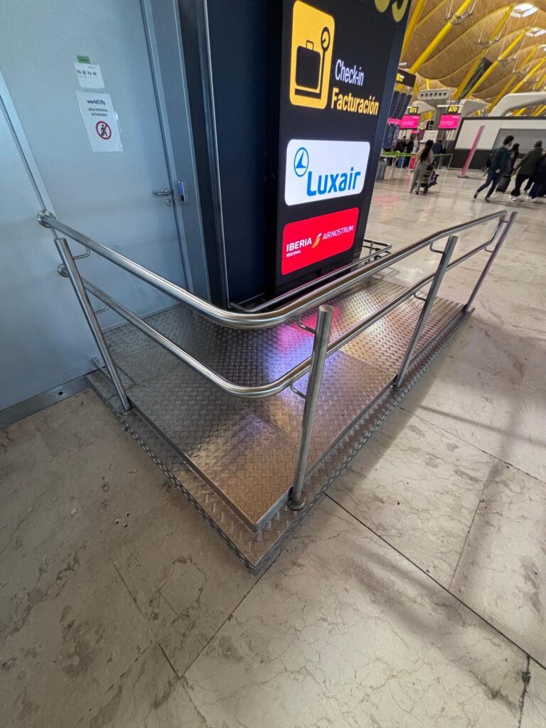 Barandillas y rampas de acero inoxidable instaladas en terminal de aeropuerto para mejorar accesibilidad